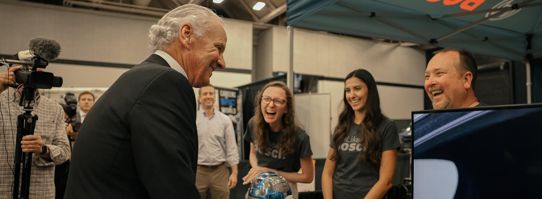 Governor McMaster laughs with a group of students. 